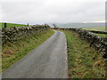 Stone wall-lined minor road heading towards Ty-tan-y-foel