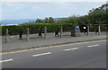 Concrete posts, wooden & metal benches and a Dylan Thomas Trail marker in New Quay