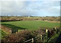 View WNW across farmland towards a farmhouse on Cumran Lane