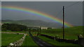 NT9911 : Rainbow on road NE from Alnham by Colin Park