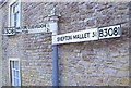 Direction Sign - Signpost against the wall of The Long House, High Street, Evercreech