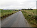 Fence-lined minor road heading in the direction of Kirton of Tough