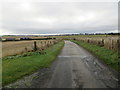 Fence-lined minor road approaching Lower Outseat