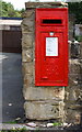 Benchmark below postbox on wall of 2 Commonside