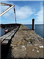 NO6107 : Crail Harbour - crane and stop planks by Chris Allen