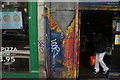 View of zip street art on a door next to Land of Burgers on Camden High Street