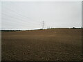 Sown field and electricity pylons