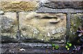 Weathered benchmark on wall fronting No. 105 Dark Lane