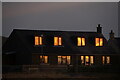 Sunrise reflected in the windows of Springpark Road, Baltasound