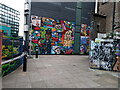 View of street art on the rear of The Old Blue Last pub and the side of the Colt building from New Inn Yard