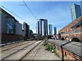 Looking down the tram tracks at the towers of Manchester