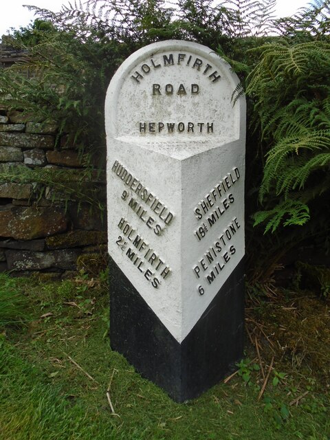 Old WRCC milestone At the top of the grassy banking in front of a stone house, this milestone was repainted in 2018.  It is on the south side of the B6106 on a bend in the road.   The metal attachment on these stones is 100cm high but there will be a further 20cms of backing stone under soil level.   This attachment was forged at the Brayshaw and Booth foundry in Liversedge.