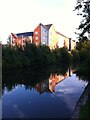 Apartment block reflected in the waters of the Coventry Canal