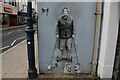 View of a mural of the Queen and her corgis on the side of an empty shop unit on High Street