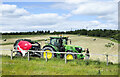 Tractor with silage baler in field