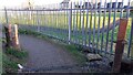 Stone gatepost beside footpath around school playing field