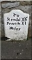 Old milestone outside The Greyhound Hotel on NE side of Main Street