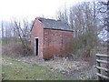 Small brick building in a field