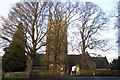 Tower of St Briavels church behind tall trees