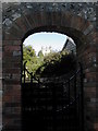 Piddletrenthide Church tower through an archway.