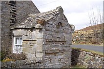 NY8397 : Old schoolhouse porch made from Roman stones brought from the fort at Bremenium by John Watson