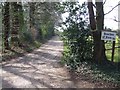 Track alongside woodland to Houchen Farm