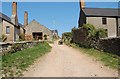 Bridleway between farm buildings.