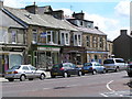 NY9425 : Shops opposite fountain and ironmongers. by Robin Madge