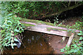 Small timber footbridge crosses tributary to Roe Beck