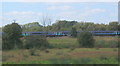 Looking across fields to northbound train