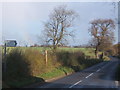 Lane at turn for Aldham church with rainbow as wintry shower passes