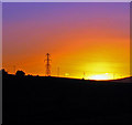 Power lines and pylon on the skyline at sunset