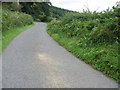 Country road approaching a wooded escarpment